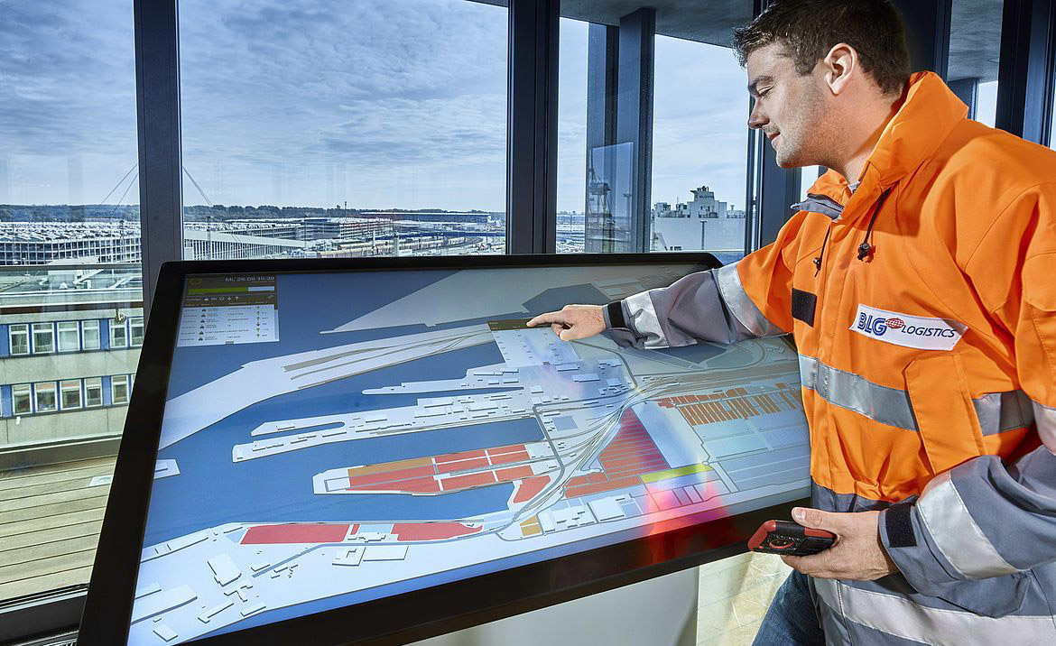 Mitarbeiter von BLG LOGISTICS steht vor dem Isabella Touchtisch.