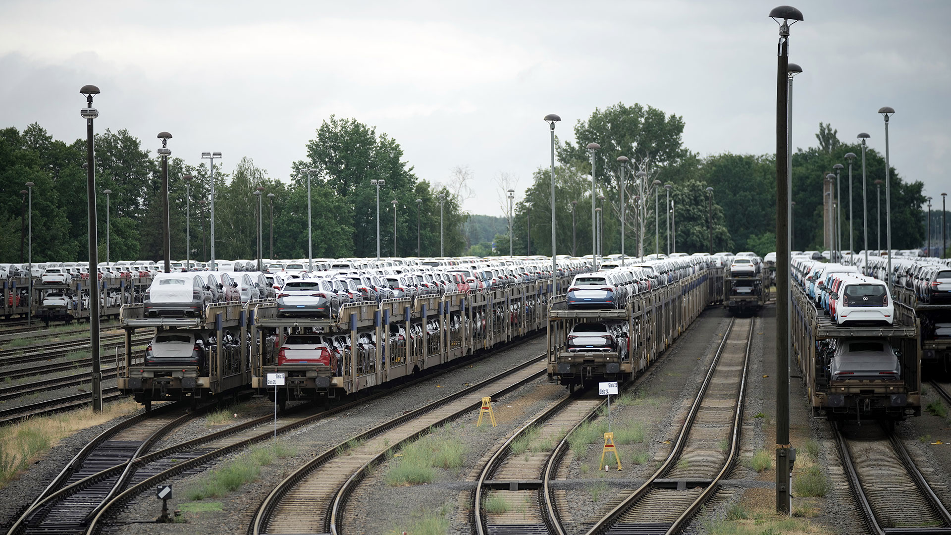 Nachhaltige Logistik via Schienenverkehr - Mehrere stehende Güterwagons, die mit Autos beladen sind.