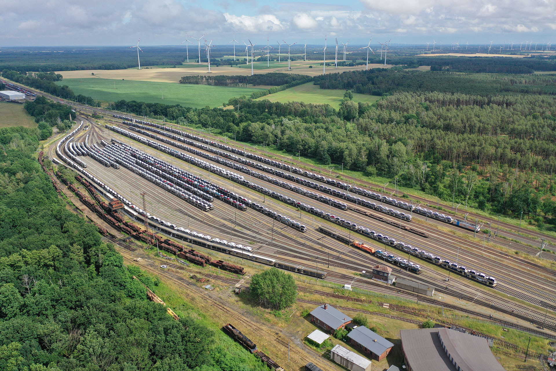 Nachhaltige Logistik in Falkenberg- Luftaufnahme der mit Autos beladenen Güterwagons, aus der Automobillogistik. 