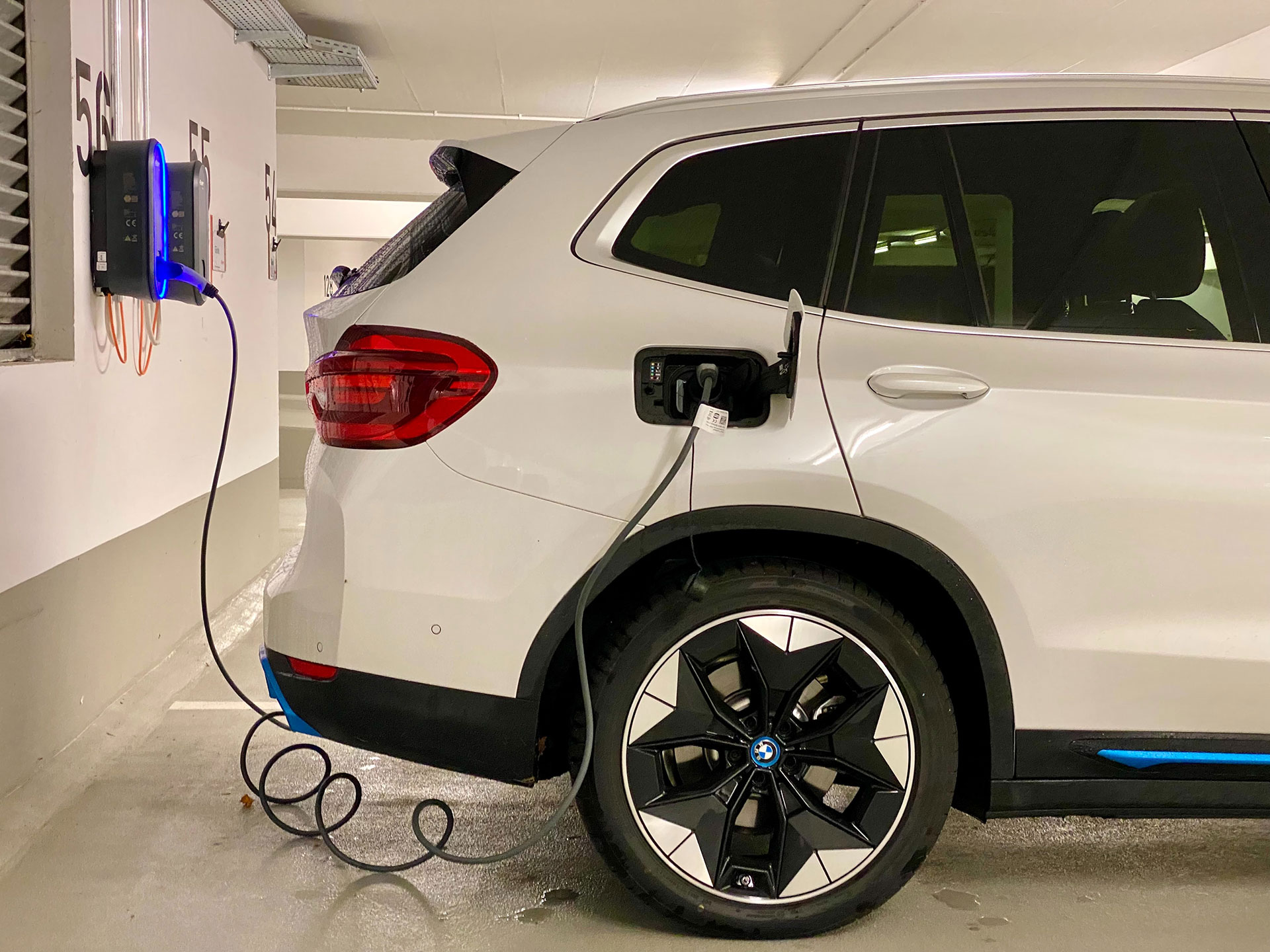 Ein Automobil, dass an einer Ladesäule geladen wird. Ein Sinnbild für nachhaltige Logistik durch geringe Emissionen.