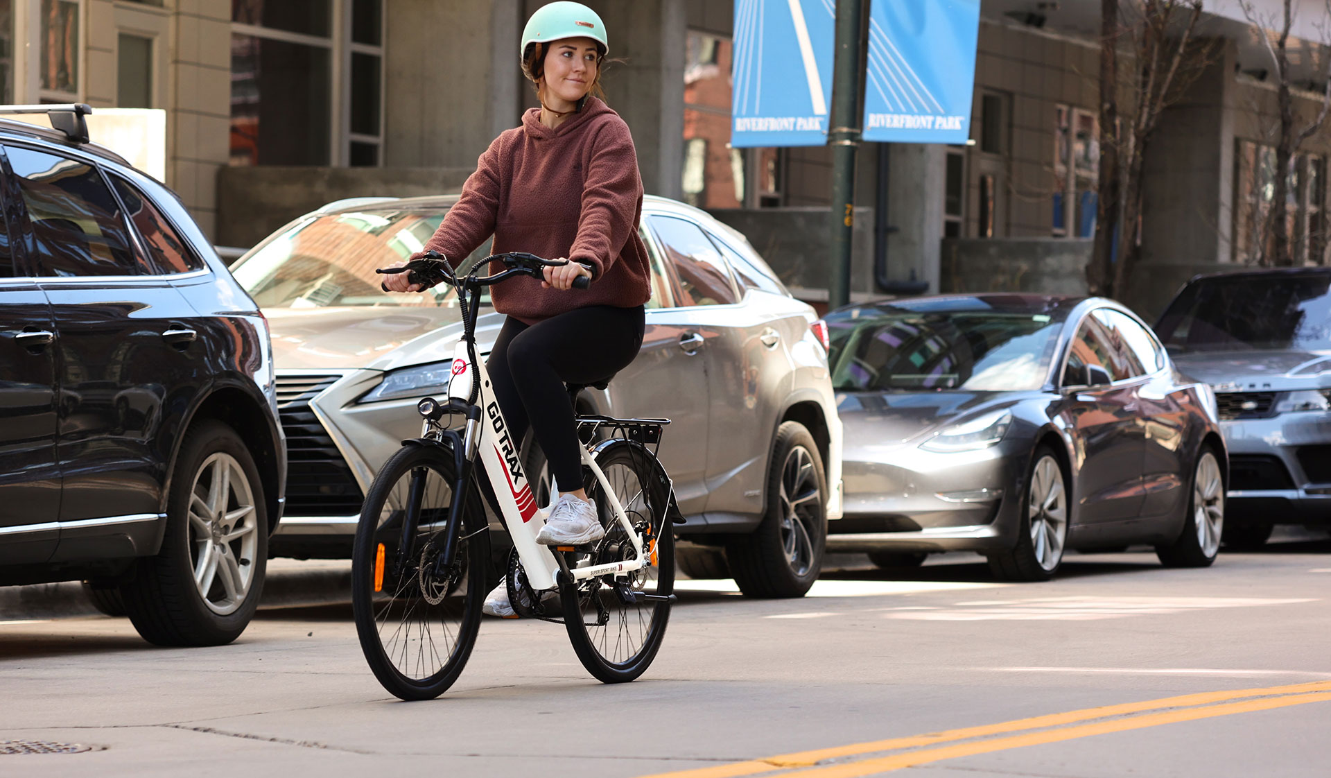 Eine junge Frau auf einem Elektrofahrrad, die sinnbildlich für eine Nachhaltige Logistik durch nachhaltige Mobilität steht.