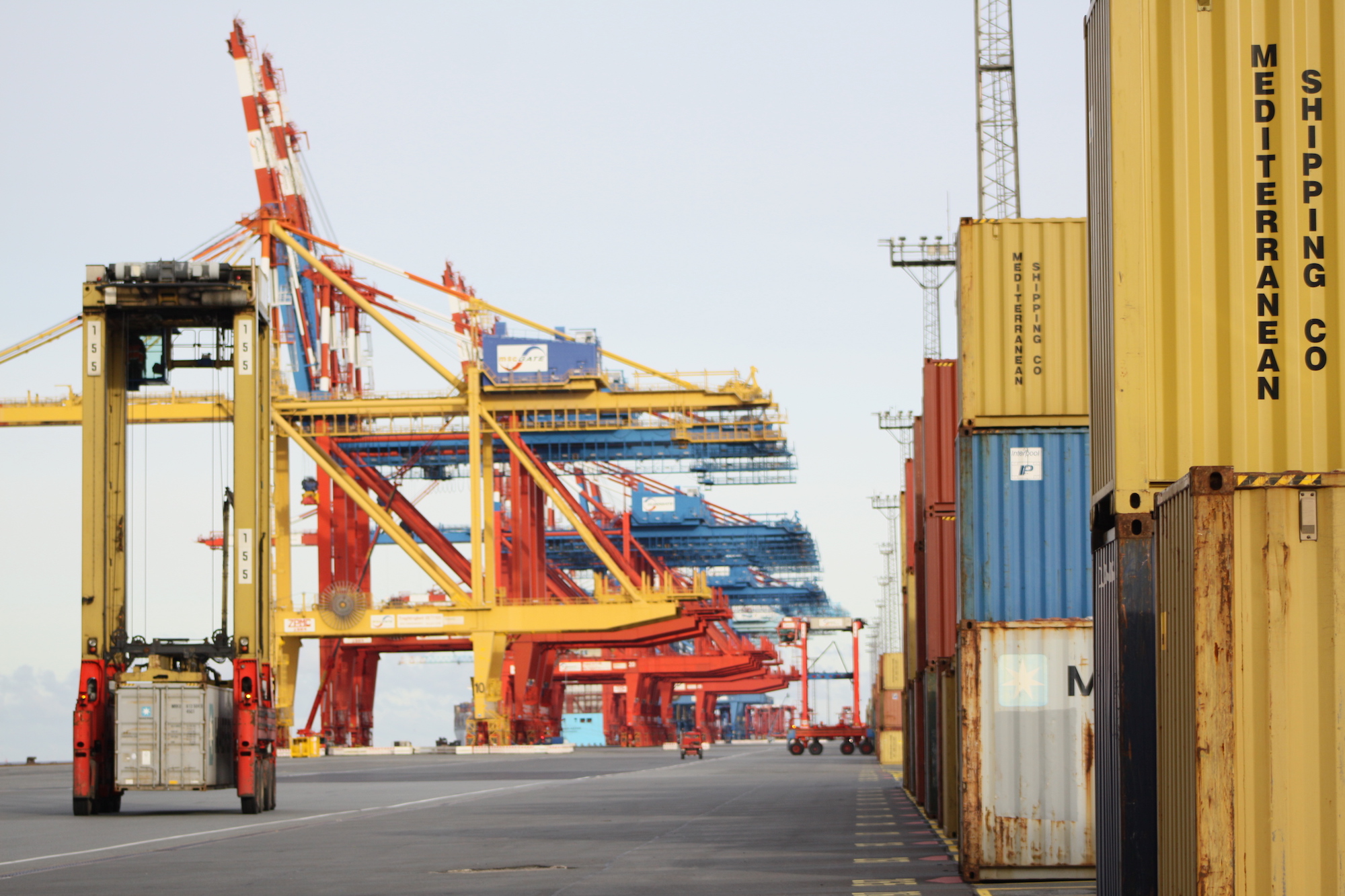 Kräne stehen neben Containern im Hafen
